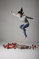 Young Asian woman jumping on cans - Asia Images Group