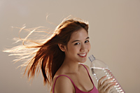 Asian girl holding bottle water with hair blowing - Asia Images Group