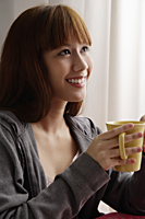 Asian girl holding coffee mug - Asia Images Group