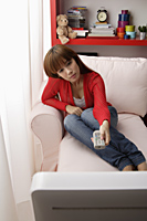 Asian girl watching TV at home - Asia Images Group
