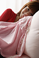 Asian girl resting on pink sofa - Asia Images Group