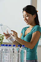 Young Asian woman recycling water bottles - Asia Images Group