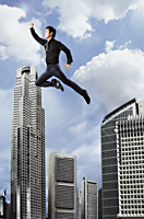 man flying in the sky over buildings - Asia Images Group