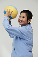 Mature woman throwing a volleyball - Asia Images Group