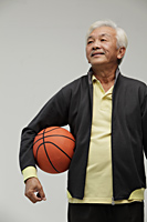 Mature Chinese man holding a basketball - Asia Images Group