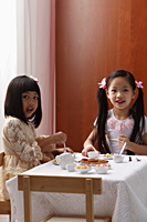 two little girls having a tea party - Asia Images Group