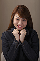 Young woman smiling with hands under chin - Asia Images Group