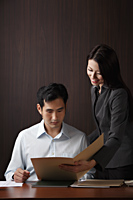 Man and woman looking at folder - Asia Images Group