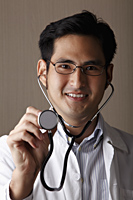 head shot of male doctor with stethoscope - Asia Images Group