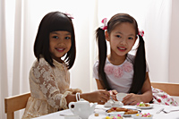two little girls having a tea pary - Asia Images Group