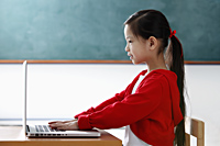 Profile of young girl looking at the computer - Asia Images Group