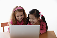 two young girls looking at laptop - Asia Images Group