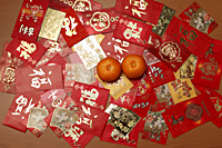 Man different Hong Baos, red envelopes with oranges. - Asia Images Group