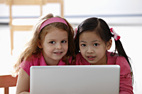 two young girls playing with laptop - Asia Images Group