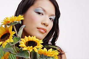 Young woman, with bouquet of sunflowers, looking at camera - Asia Images Group