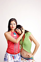 Two women facing camera, one embracing the other - Asia Images Group