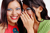 Two women, one smiling at camera, the other whispering to her - Asia Images Group