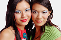 Two women looking at camera, wearing blue eye shadow - Asia Images Group