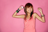 Young woman smiling, using headphones - Asia Images Group