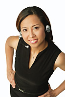 Woman using headset, smiling up at camera - Asia Images Group