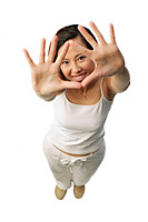 Woman looking at camera, through her hands - Asia Images Group