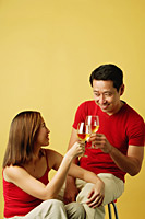 Couple sitting, toasting with drinks - Asia Images Group