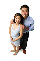 Couple standing side by side, smiling at camera - Asia Images Group