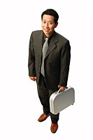 Businessman with briefcase, smiling at camera - Asia Images Group