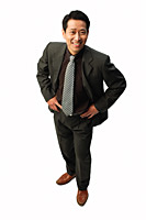Businessman with hands on hips, smiling at camera - Asia Images Group
