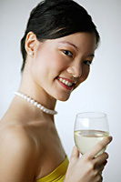 Woman holding wine glass, smiling at camera, portrait - Asia Images Group