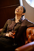 Woman with champagne glass, looking up, smiling - Asia Images Group