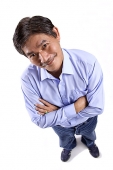 Mature man looking at camera, arms crossed - Asia Images Group