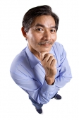 Mature man looking at camera, hand on chin - Asia Images Group