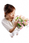 Woman standing, smelling bouquet of flowers - Asia Images Group