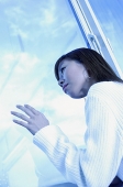 Woman leaning head on window, looking out - Asia Images Group