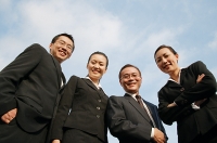 Businessmen and businesswomen looking down at camera, smiling - Asia Images Group