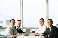 Executives sitting at lunch table, smiling at camera - Asia Images Group