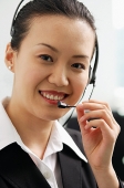 Woman wearing headset, looking at camera - Asia Images Group