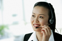 Woman wearing headset, smiling - Asia Images Group