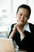 Businesswoman looking at camera, hands clasped - Asia Images Group