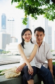 Young couple sitting on park bench, looking at camera - Asia Images Group