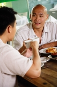 Two men at a cafe, eating - Asia Images Group