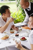 Couple in restaurant, man making payment with credit card - Asia Images Group