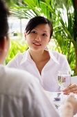 Woman looking at man sitting across table from her - Asia Images Group