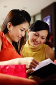 Two women looking at a book - Asia Images Group