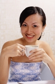 Woman holding cup, looking at camera - Asia Images Group