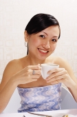 Woman holding cup, looking at camera, portrait - Asia Images Group