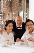 Waiter and customers at restaurant, looking at camera, smiling - Asia Images Group