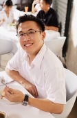 Man at restaurant, having dessert, smiling at camera - Asia Images Group