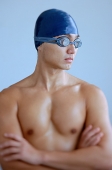 Man wearing swimming cap and goggles, arms crossed - Asia Images Group